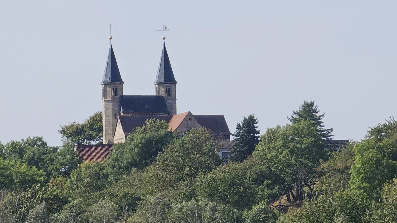 Die beiden Türme der Basilika St. Gangolf über den Bäumen von Münchenlohra.