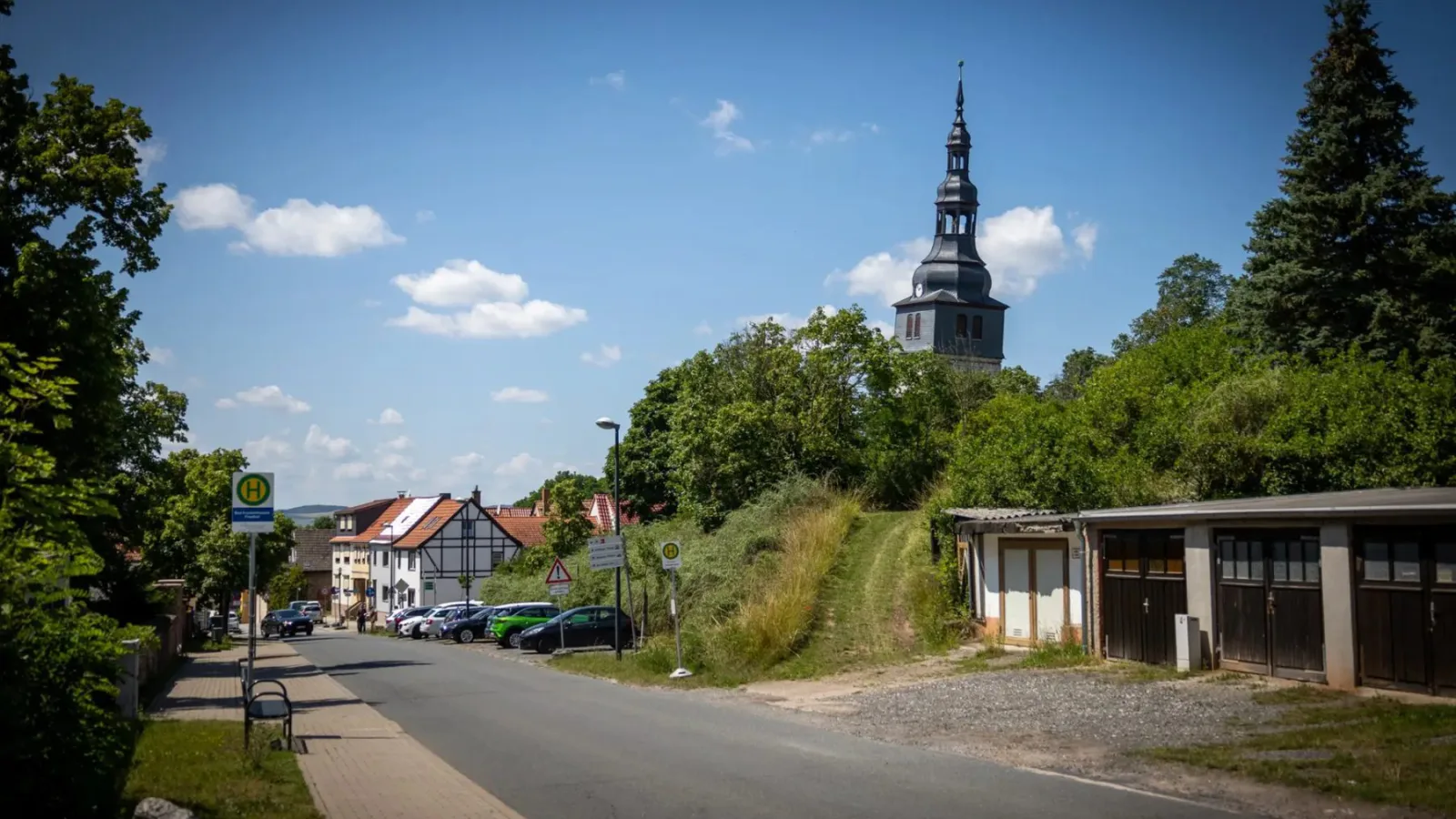 Straße in Bad Frankenhausen mit dem deutlich geneigten Kirchturm im Hintergrund.